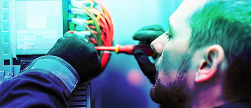 Closeup of electrician engineer works with electric cable wires of fuse switch box. Electrical equipment